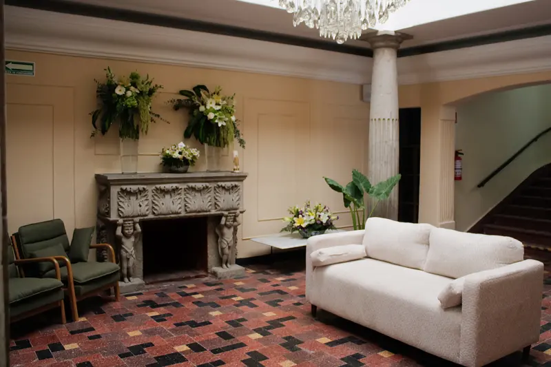 Sala de estar con chimenea de cantera labrada y sillones