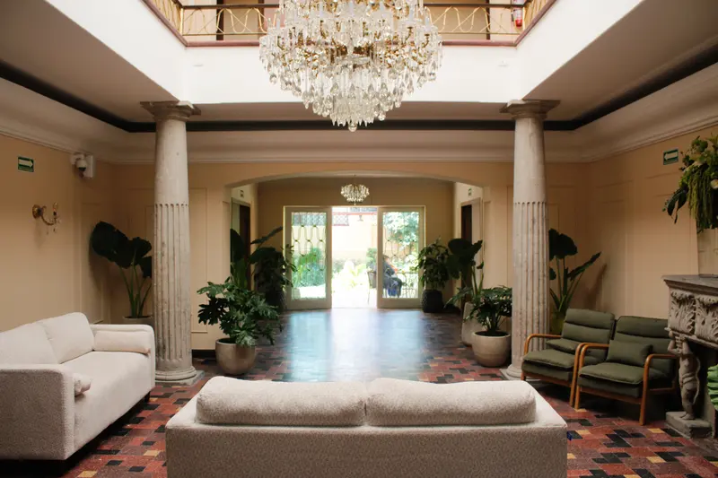 Salón principal de doble altura con puertas hacia el jardín